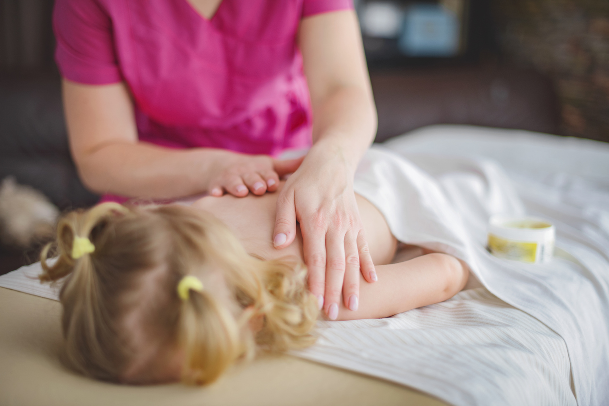 Kind wird von therapeutin massiert