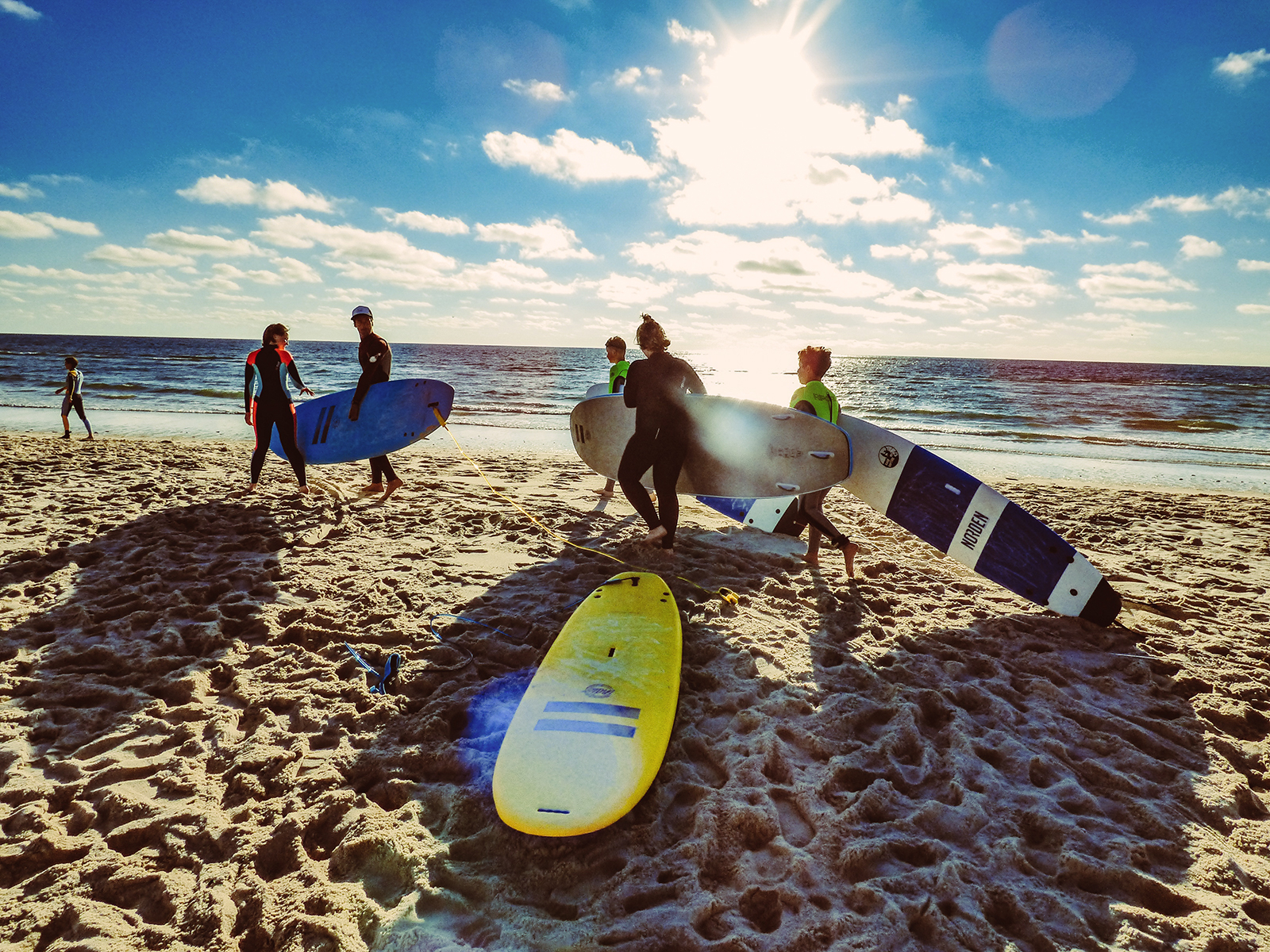 kinder mit surfbrettern an strand