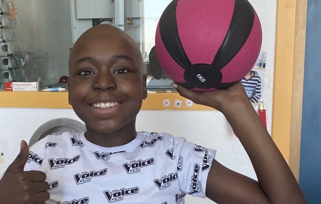 Kind mit Basketball, dass den Daumen nach oben streckt