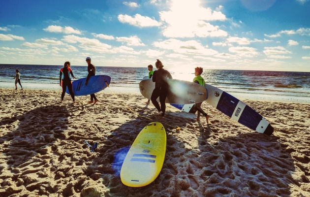 Kinder am Strand mit Surfbrettern